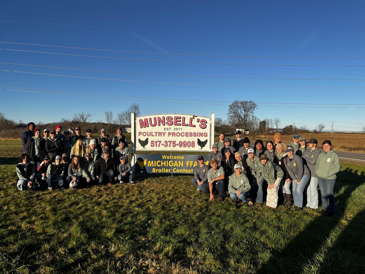 Class of CTC students standing in front of Munsells sign