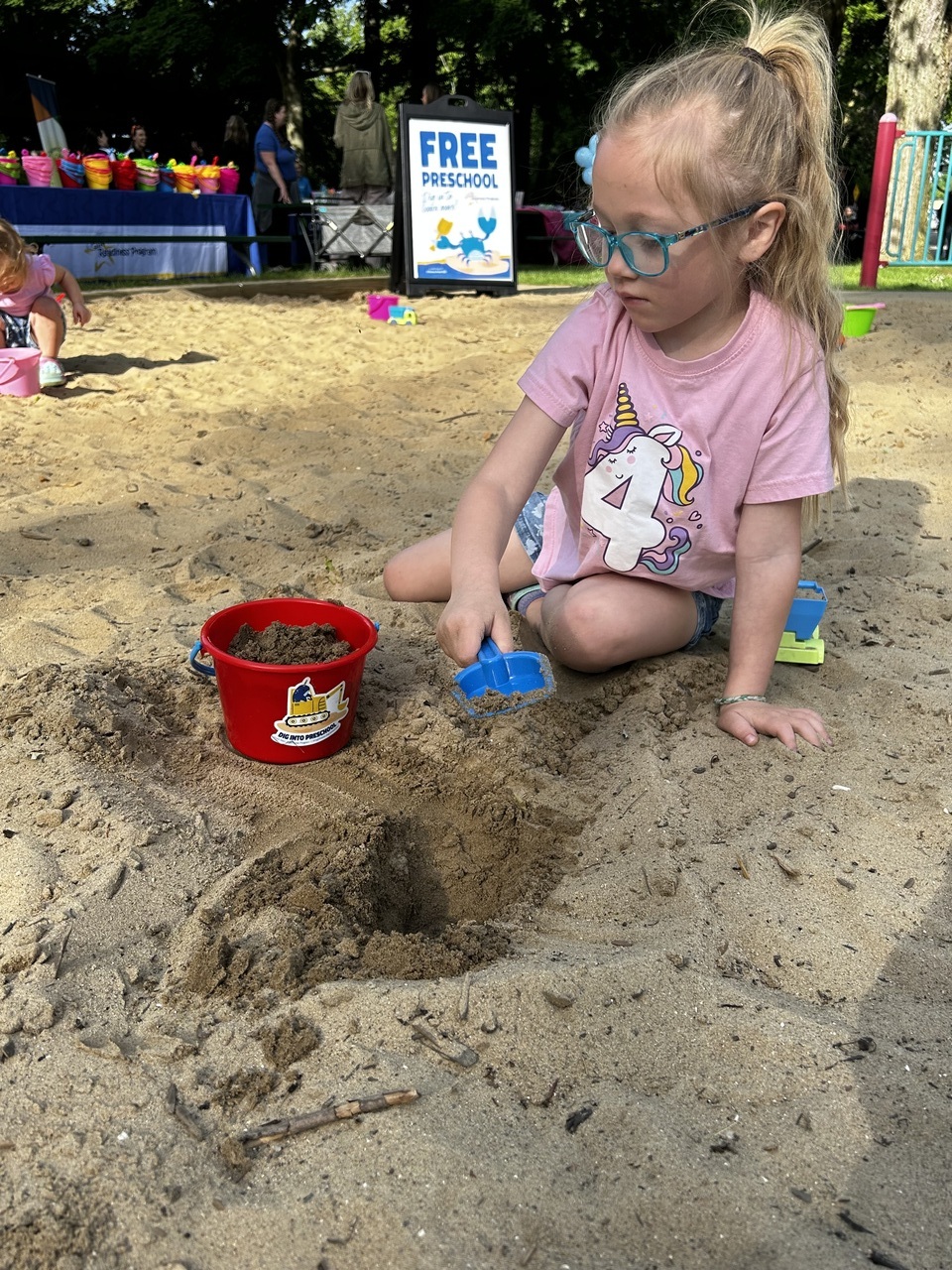 child in sandbox at kids day